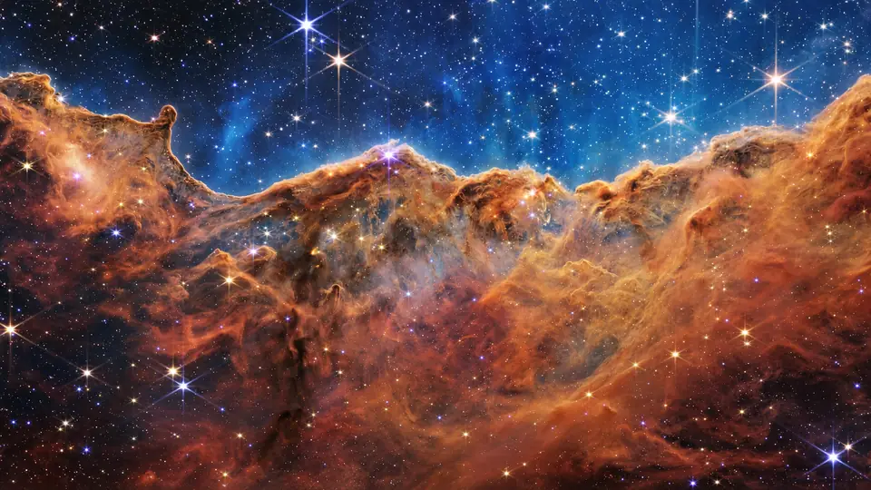 船底座星云的气体与尘埃悬崖，蓝色星空中散布明亮恒星，基于 NASA 韦伯影像的 AI 构图处理